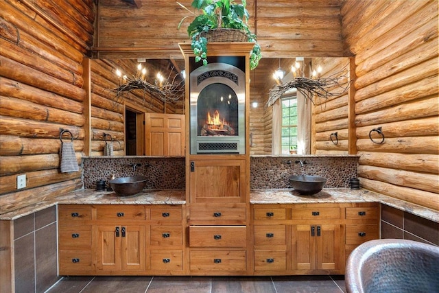 W2470 County Road B, Montello, WI 53949 - kitchen featuring a sink, rustic walls, light stone countertops, and brown cabinets