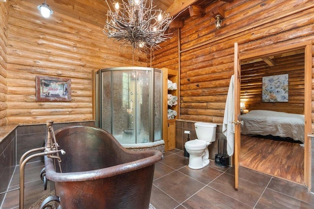 W2470 County Road B, Montello, WI 53949 - ensuite bathroom featuring log walls, a chandelier, toilet, tile patterned floors, and a freestanding tub