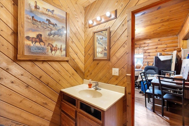 W2470 County Road B, Montello, WI 53949 - bathroom featuring vanity, wood finished floors, log walls, and wood walls