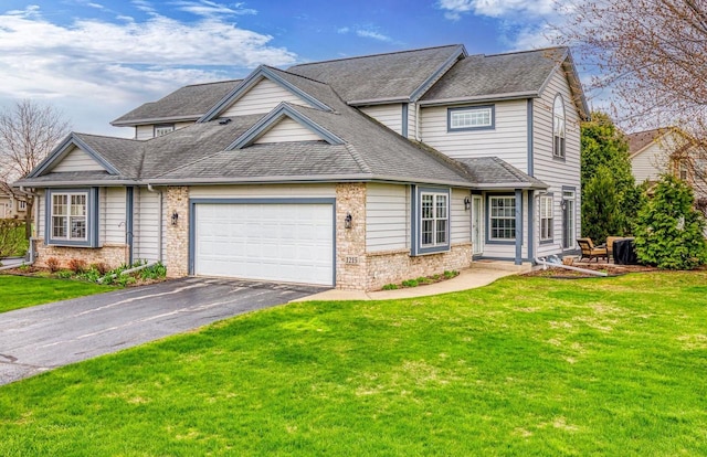 traditional home with an attached garage, brick siding, driveway, and a front yard