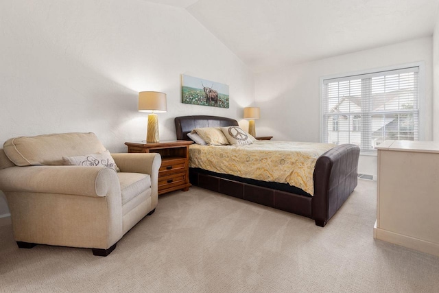 bedroom with light colored carpet and lofted ceiling