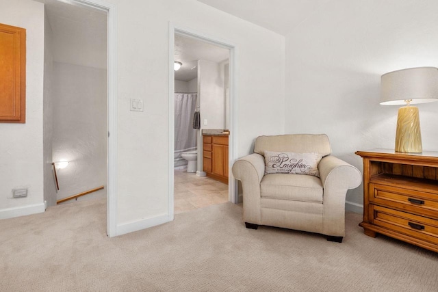 living area with light colored carpet and baseboards