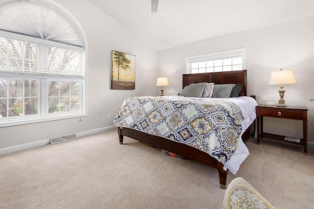 carpeted bedroom featuring a ceiling fan, visible vents, baseboards, and lofted ceiling