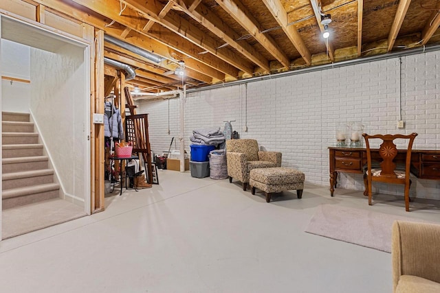 unfinished below grade area featuring stairway and brick wall