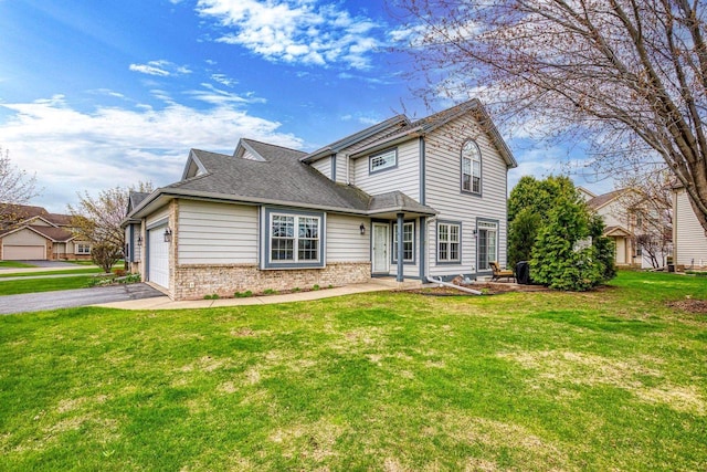 traditional home with a front yard, brick siding, aphalt driveway, and an attached garage