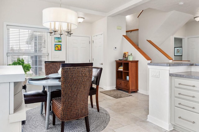 dining room with a chandelier, baseboards, and stairs
