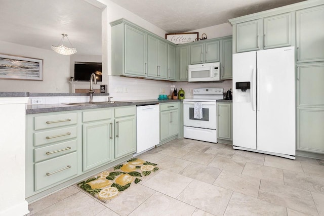 kitchen featuring a sink, white appliances, hanging light fixtures, and green cabinetry