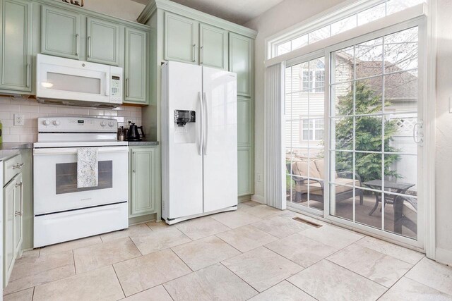 kitchen featuring visible vents, tasteful backsplash, green cabinets, and white appliances