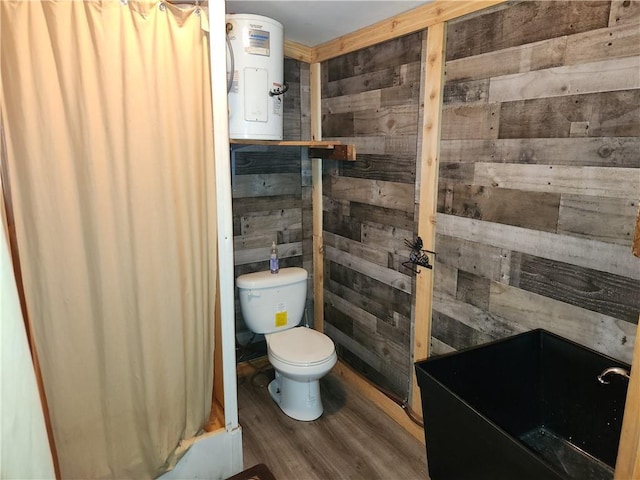 bathroom featuring toilet, wood walls, and wood finished floors