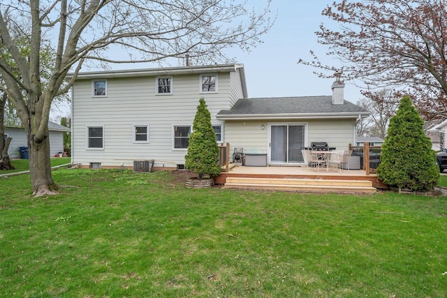 rear view of house featuring a yard, a chimney, and a deck