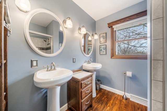 full bath featuring two sinks, baseboards, visible vents, and wood finished floors
