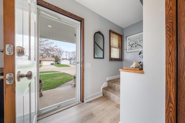 foyer entrance with stairway, baseboards, and wood finished floors