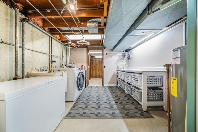 laundry area with washing machine and clothes dryer, laundry area, water heater, and a sink