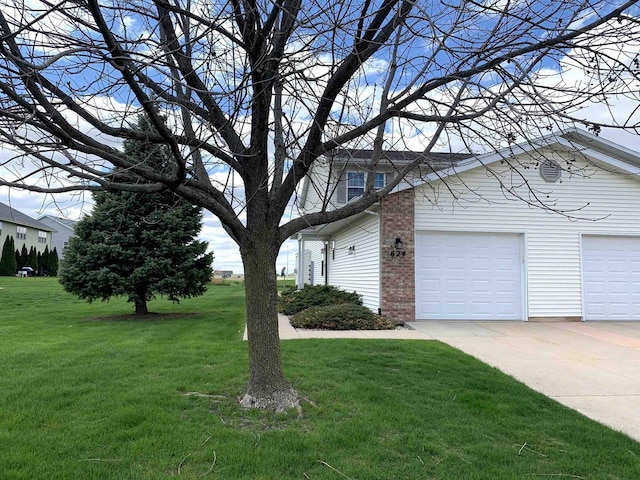 view of side of home with a lawn, brick siding, a garage, and concrete driveway