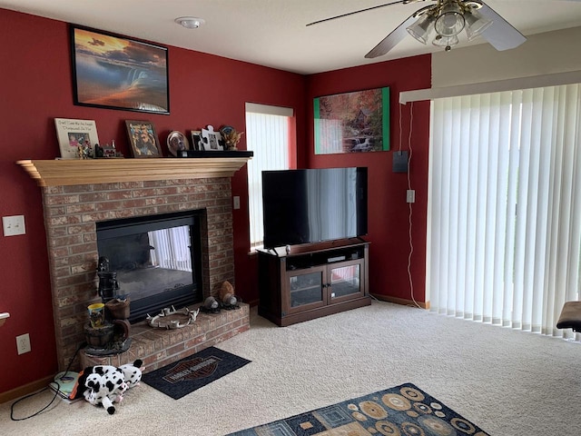 carpeted living area featuring baseboards, a fireplace, and a ceiling fan