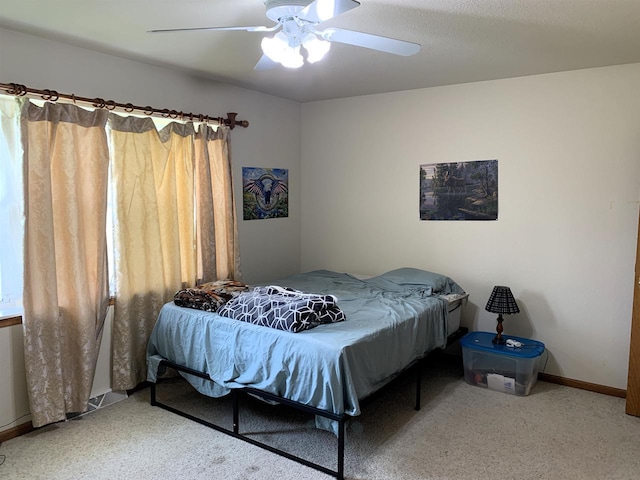 carpeted bedroom featuring baseboards and ceiling fan