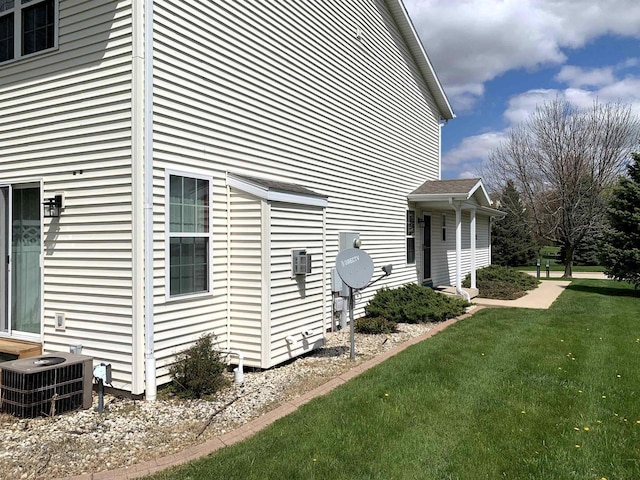 view of home's exterior featuring central AC unit and a lawn