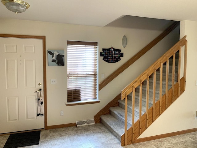 entryway with baseboards, stairs, and visible vents