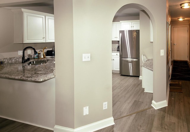 7515 W Mallory Way, Franklin, WI 53132 - hall featuring wood finished floors, baseboards, arched walkways, and a sink
