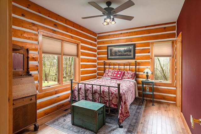 bedroom featuring rustic walls and hardwood / wood-style floors
