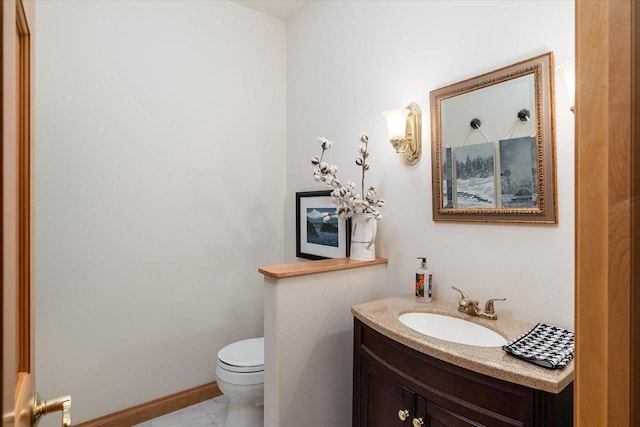 bathroom with toilet, baseboards, and vanity
