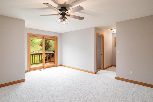 spare room with carpet flooring, baseboards, and ceiling fan