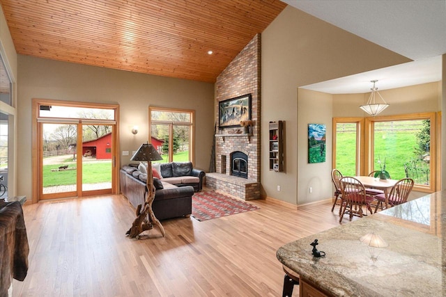 living area with wooden ceiling, baseboards, high vaulted ceiling, light wood-style floors, and a fireplace