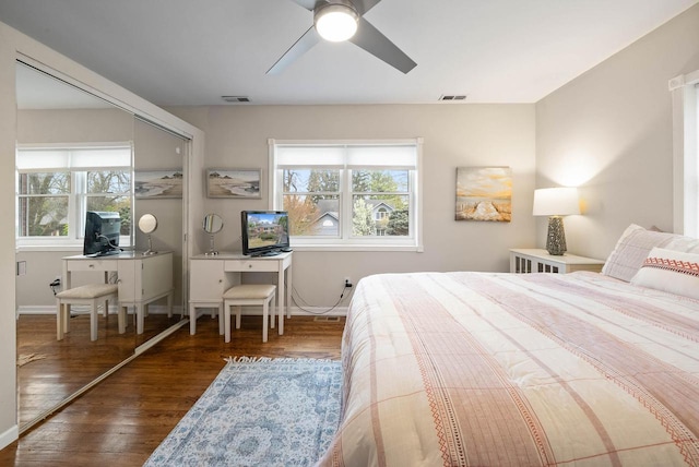bedroom with ceiling fan, baseboards, visible vents, and wood finished floors