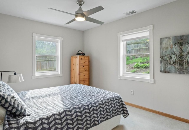 carpeted bedroom featuring visible vents, baseboards, and ceiling fan