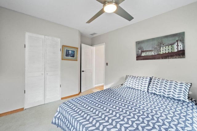 carpeted bedroom featuring baseboards, a closet, visible vents, and ceiling fan
