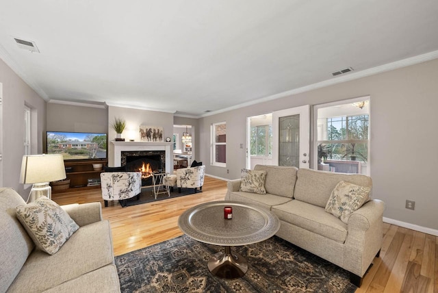 living room with visible vents, baseboards, and hardwood / wood-style flooring