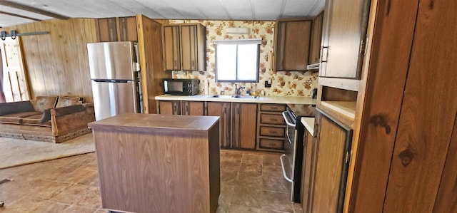 N7120 Sullivan Ln, New Lisbon, WI 53950 - kitchen featuring freestanding refrigerator, a sink, black microwave, a kitchen island, and brown cabinets