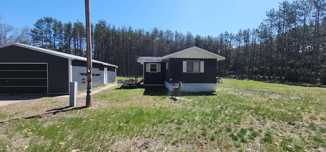 N7120 Sullivan Ln, New Lisbon, WI 53950 - view of home's exterior with an outbuilding, a lawn, a garage, and a forest view