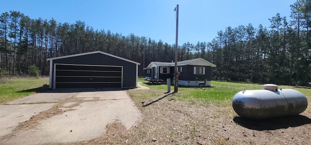 N7120 Sullivan Ln, New Lisbon, WI 53950 - manufactured / mobile home featuring a detached garage, an outbuilding, a front lawn, and a wooded view