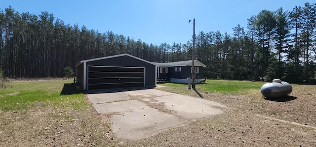 N7120 Sullivan Ln, New Lisbon, WI 53950 - garage with driveway and a view of trees