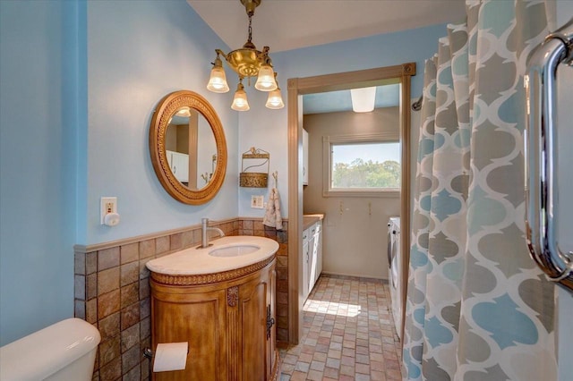 3756 E County Rd N, Milton, WI 53563 - bathroom featuring tile walls, vanity, toilet, a wainscoted wall, and brick patterned floors