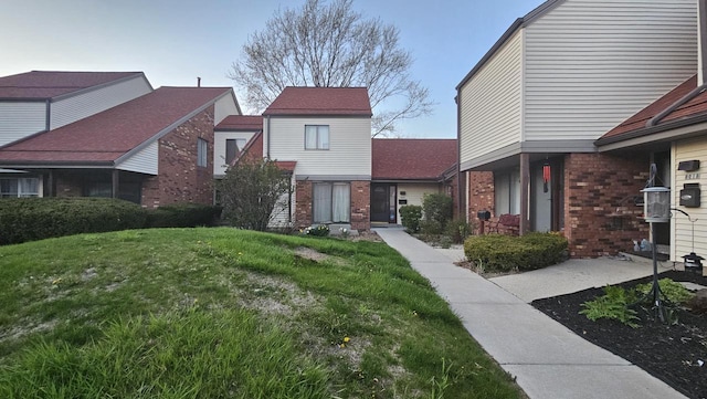 view of front of property featuring a front yard and brick siding