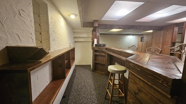 bar with wooden walls, a bar, and carpet