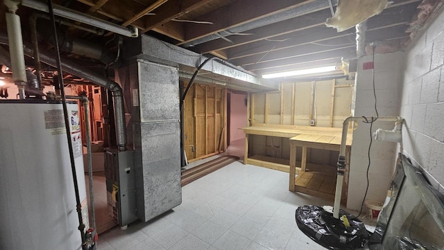 unfinished basement featuring tile patterned floors, water heater, concrete block wall, and heating unit