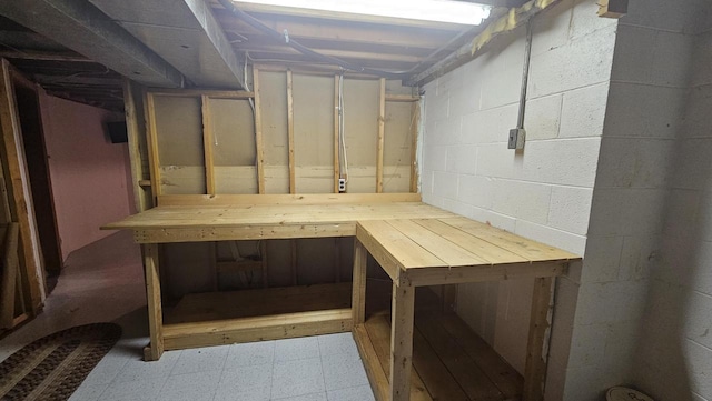 unfinished below grade area featuring tile patterned floors and concrete block wall