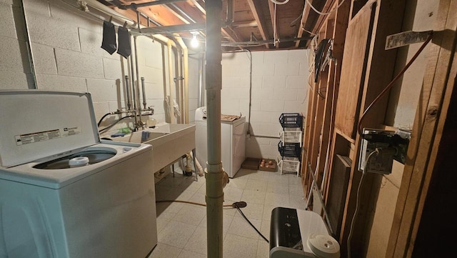 laundry area with a sink, laundry area, light floors, and separate washer and dryer