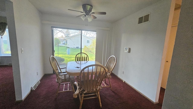 dining area with carpet flooring, visible vents, and ceiling fan