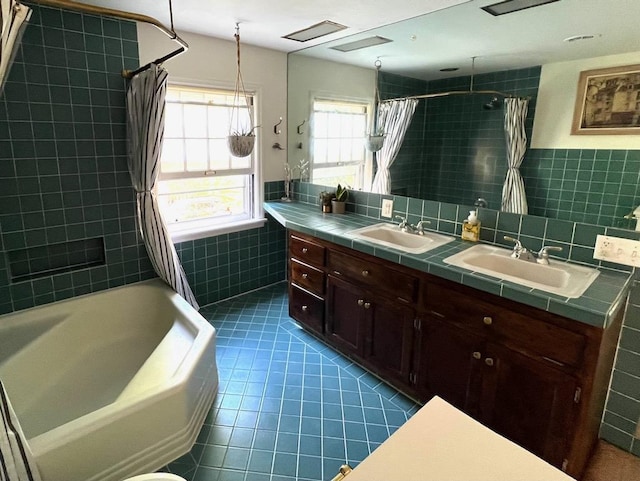 1651 E Ridge Rd, Beloit, WI 53511 - full bathroom featuring tile walls, tile patterned flooring, double vanity, shower / bathtub combination with curtain, and a wainscoted wall