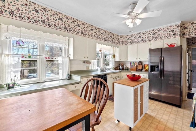 kitchen with a sink, light floors, a kitchen island, a ceiling fan, and stainless steel fridge with ice dispenser
