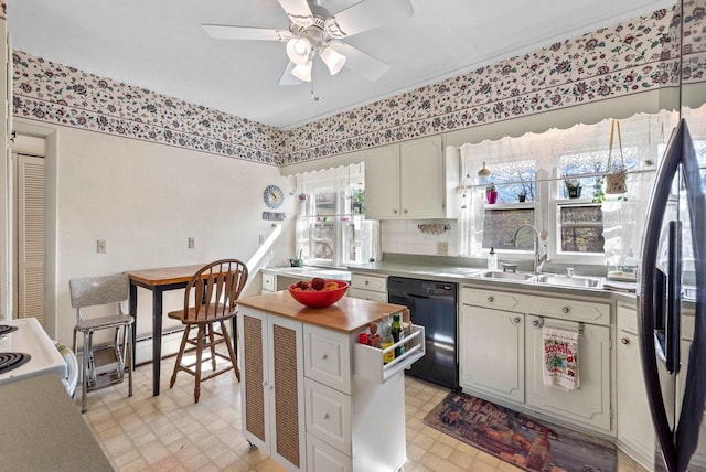 kitchen featuring a sink, freestanding refrigerator, light floors, dishwasher, and a ceiling fan