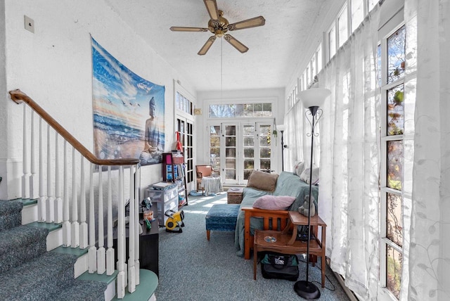 sunroom / solarium featuring carpet flooring, a textured ceiling, and french doors