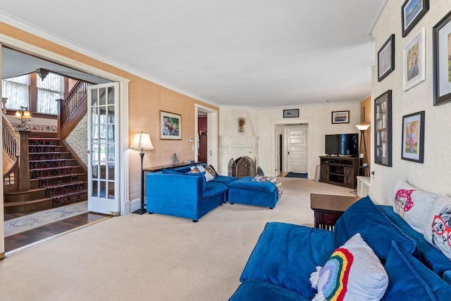 living room with a brick fireplace, carpet floors, baseboards, ornamental molding, and stairs