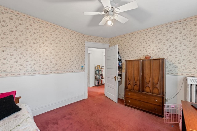 bedroom featuring a ceiling fan, carpet floors, wallpapered walls, and a wainscoted wall