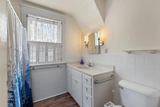 full bath featuring lofted ceiling, tile walls, toilet, vanity, and wood finished floors