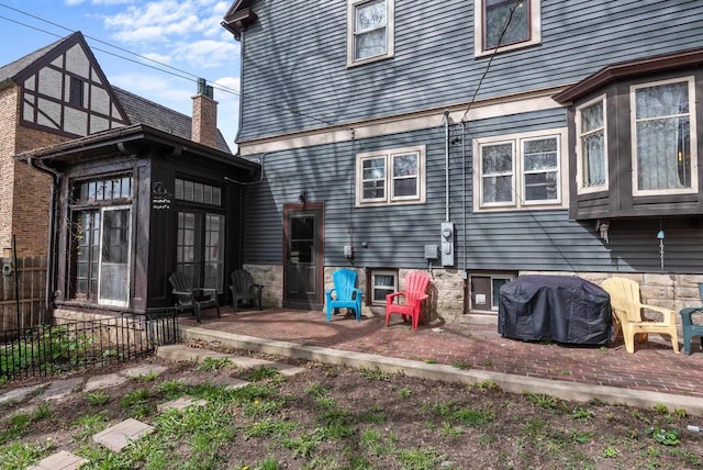 back of property featuring a patio, a sunroom, and fence